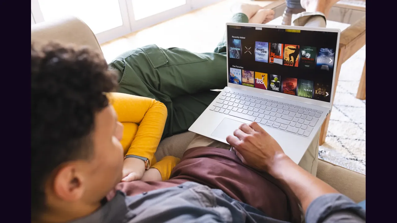 A person watching a streaming library on a laptop at home