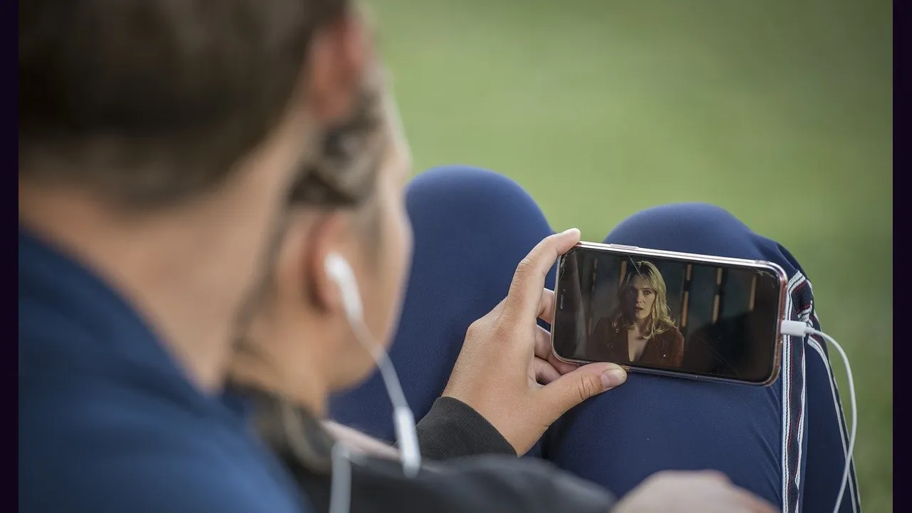 A person watching video on a phone while outdoors
