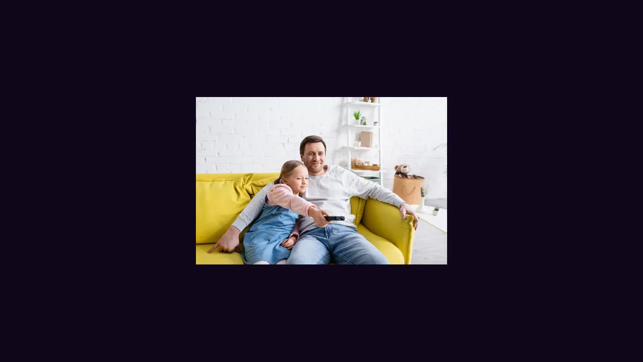 A parent and a child watching television together on a sofa